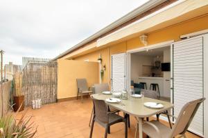 a patio with a table and chairs on a balcony at Atic Els Pins in L'Estartit