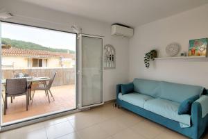 a living room with a blue couch and a table at Atic Els Pins in L'Estartit +8 photos