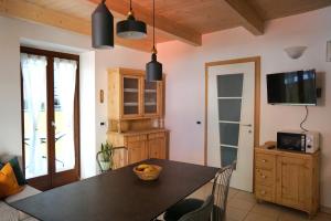 a kitchen with a dining room table and a tv at Casa Filomena in Nago-Torbole