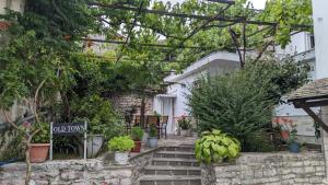 a garden with plants and a sign on the stairs at Old Town Hotel in Gjirokastër