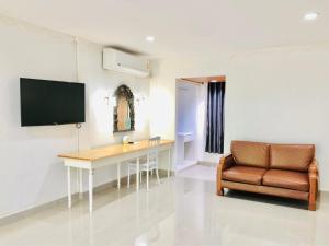 a living room with a desk and a chair at Dad D Resort by Lopburi Inn Resort in Lop Buri
