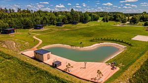 eine Luftaufnahme eines Teiches auf einem Feld in der Unterkunft Five Pine Resort in Darbėnai