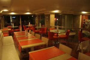 a restaurant with tables and red chairs and tablesearcher at Anzac Hotel in Çanakkale