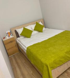 ein Schlafzimmer mit einem Bett mit grünen Laken und Kissen in der Unterkunft Temple Inn in Garni + 9 Fotos