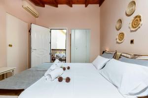 a bedroom with a white bed with towels on it at Anna's Village House in Perivólia
