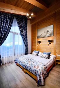 une chambre avec un lit et une grande fenêtre dans l'établissement CHALET MOUNTAIN, à Demänovská Dolina
