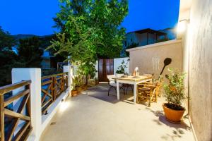 a patio with a table and chairs on a balcony at Anna's Village House in Perivólia +33 photos