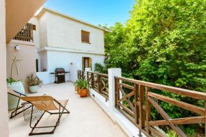 a balcony of a house with chairs and trees at Anna's Village House in Perivólia