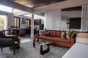 a living room with a couch and a table at Shanti Cabin - Ezra Viniti Resort in Tagaytay