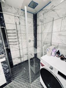 a bathroom with a shower and a washing machine at The Place to be in Stockholm Old Town in Stockholm