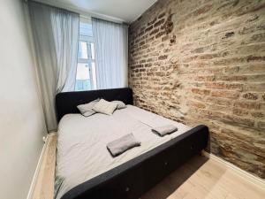 a bed in a room with a brick wall at The Place to be in Stockholm Old Town in Stockholm +6 photos