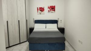 a bed in a room with two pictures on the wall at NR89 Apartments, by ferry to Valletta in 10 minutes in Il-Gżira