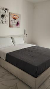 a bed in a bedroom with two paintings on the wall at NR89 Apartments, by ferry to Valletta in 10 minutes in Il-Gżira