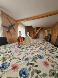 a dining room table with a floral tablecloth on it at Cabana Măgura in Măgura