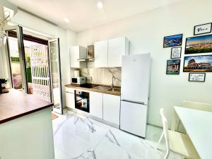 a kitchen with white cabinets and a white refrigerator at Licheni R-home in Rome