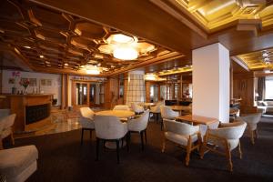 a lobby with tables and chairs in a building at Hotel Engel in Canazei