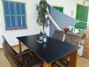 einem schwarzen Tisch mit 2 Stühlen und einem blauen Fenster in der Unterkunft Wunderschöne Ferienwohnung in Porto Cristo mit Terrasse und Garten in Porto Cristo