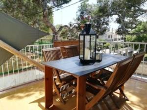 einen Holztisch mit Stühlen auf dem Balkon in der Unterkunft Wunderschöne Ferienwohnung in Porto Cristo mit Terrasse und Garten in Porto Cristo