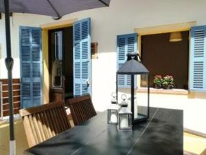 ein schwarzer Tisch mit einem Sonnenschirm auf einer Terrasse in der Unterkunft Wunderschöne Ferienwohnung in Porto Cristo mit Terrasse und Garten in Porto Cristo + 10 Fotos