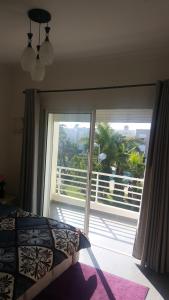 a bedroom with a large window with a view of a balcony at Luxury Villa in Sidi Rahal Residence Dar el Bahr in Casablanca