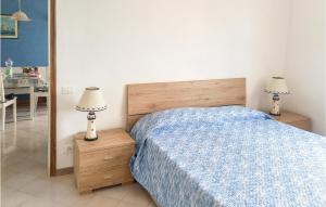 a bedroom with a bed with a blue blanket and two lamps at Roberta in Rosignano Solvay