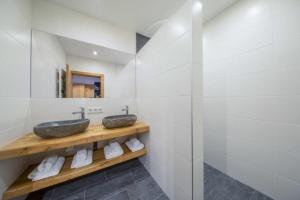 a bathroom with two sinks and a mirror at Chalet Zillertal Arena 1 in Kirchdorf +61 photos