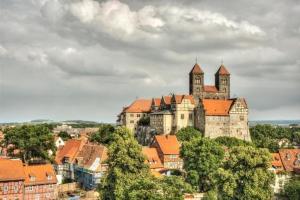 a castle on top of a hill with buildings at Gästezimmer in kleiner Ferienanlage mit vielen Freizeitmöglichkeiten in Harzgerode