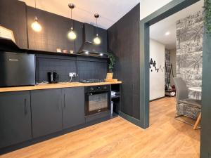 a kitchen with black cabinets and a wooden floor at INNit Bliss in Brighton & Hove