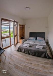 a bedroom with a large bed and a wooden floor at Pokoje Gościnne nad Rożnowskim in Gródek Nad Dunajcem
