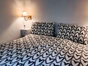 a bedroom with a bed with a black and white bedspread at Nel Bosco di Giove - Albergo Diffuso in Collegiove
