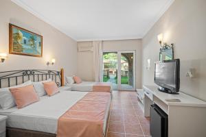 a bedroom with a bed and a flat screen tv at Alados Otel in Turgut