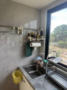 Una pequeña cocina con fregadero y ventana. en Tiny home by the River in Thailand, en Phra Nakhon Si Ayutthaya