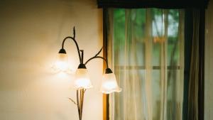 Un par de luces en una pared al lado de una ventana. en Auberge A MA FACON, en Kokonoe