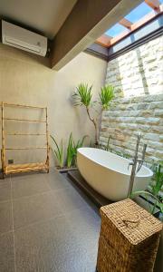 a bath tub in a bathroom with plants at HomeSix Bali in Uluwatu