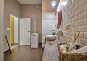 une salle de bain avec un lavabo et un miroir sur un comptoir dans l'établissement Gîte de charme entre campagne et montagne, à Corbelin 45 autres photos