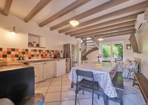 - une cuisine avec une table, des chaises et une table dans l'établissement Gîte de charme entre campagne et montagne, à Corbelin