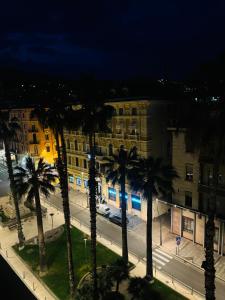 a group of palm trees in front of a building at La Mombellina OLTRE HOME HOLIDAYS in Sanremo