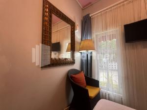 a room with a mirror and a chair and a window at Villa Layar Selorejo Mitra RedDoorz in Malang