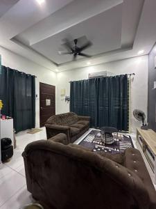 a living room with two couches and a ceiling fan at FS homestay bertam in Kepala Batas