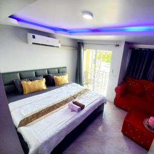 a bedroom with a large bed with purple lights at SUKANO Apartment VIP in Ban Khlong Chao