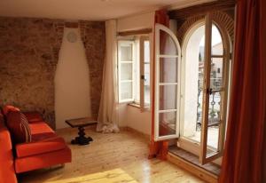 a living room with two windows and a couch at Liebevoll eingerichtetes istrisches Steinhaus mit großer überdachter Terrasse in zentraler Lage in Vižinada