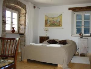 a bedroom with a bed and two windows at Liebevoll eingerichtetes istrisches Steinhaus mit großer überdachter Terrasse in zentraler Lage in Vižinada