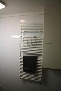 a towel rack in a bathroom with a black towel at Bed & Breakfast Klokgaaf in De Koog
