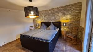 a bedroom with a bed and a brick wall at Ferienwohnung Altstadt in Annaberg-Buchholz