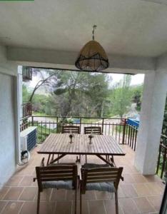 une table et des chaises en bois sur une terrasse dans l'établissement Flat with lake views - Pantano San Juan - 21, à Madrid