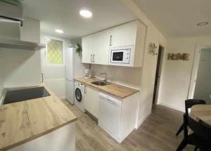 une petite cuisine avec un évier et un micro-ondes dans l'établissement Flat with lake views - Pantano San Juan - 21, à Madrid 3 autres photos