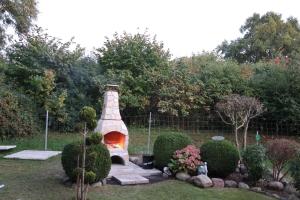 a garden with a fireplace in the middle of a yard at Ferienhaus Blomengoorn in Redewisch