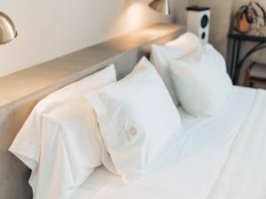 a white bed with white pillows on it at Hotel MC San José in San José