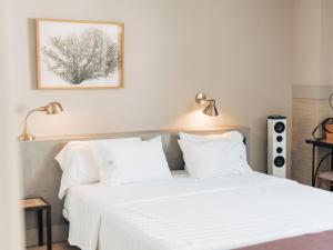 a white bed with white sheets and pillows at Hotel MC San José in San José