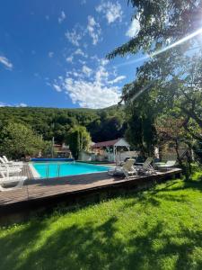 a swimming pool with chairs and a wooden deck at Casa Phoenix in Băişoara